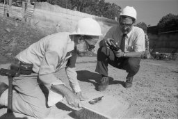 William R. Brice (left) and David W. Corson (right) inspecting bedrock on the construction site for what will become Kroch Library