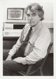 Professor Donald F. Solá sitting at a computer with a screen that reads “runa simi”