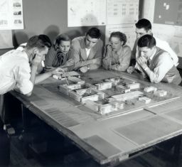 Architecture students in studio class of G. Holmes Perkins discussing a model for women's campus, 1952