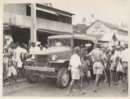 Street scene with military truck.