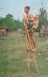 Woman With Baby Walking on Stilts