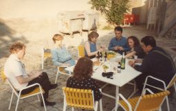 Photograph of group of people eating and drinking outside