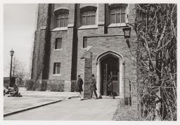 Three students walking out a back door of Willard Straight.