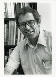 Economics professor Jules LaRocque in front of bookcase
