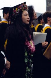 Commencement, 1982, woman graduate in cap and gown, festooned with flowers