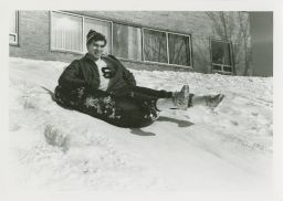 Student snow tubes down a hill