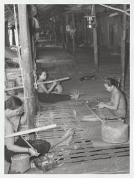 3 women seated in longhouse