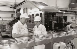 Two Workers at the Cornell Dairy Plant inspect Orange Juice