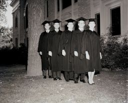 Five students stand outside on Commencement day