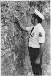Arecibo Security Policeman, (Officer Alicea) looking at engraved wall