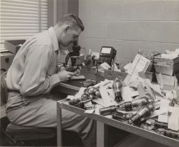 Vacuum-tube Research: Man Studies Vacuum-tube Under Microscope
