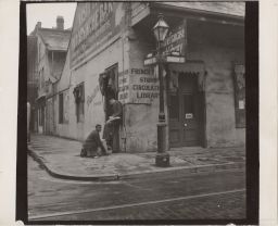 Boy shining man's shoes, Bourbon St., New Orleans, LA