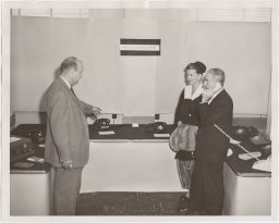 Mr. John R. Pitts (left), Communications consultant to the New York Telephone Company, demonstrates modern hotel-motel telephone communications instruments to Mr. and Mrs. Fred Waring (Hotel Adminstration)