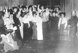 A group of women raise hands to volunteer for picket duty during the Shirtwaist strike of 1909-1910.