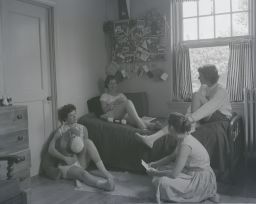 Four students lounging in Sage Hall room