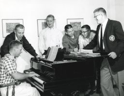Men singing at piano