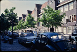 Parked cars, street trees, and nearby residential buildings along Leimudenstraat (Amsterdam, NL)