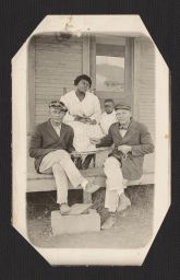 Men, woman and child sitting on porch