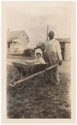 Man with child in wheelbarrow
