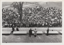 Cornell president James A. Perkins (foreground, right) and Adlai Ewing Stevenson II (speaking) on the terrace at Olin Library at at Centennial celebration