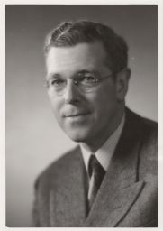 Portrait photograph of Prof. Donald Jay Grout (wearing a herringbone suit and striped shirt).