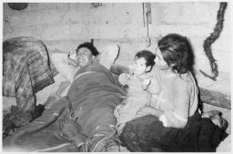 Vicosino in bed, wife and child sit at his feet