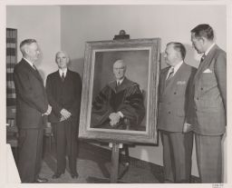 Group photo with painted portrait of Dean Emeritus Dexter S. Kimball
