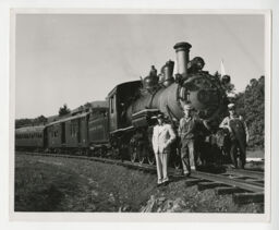 Dr. Paul S. Hill, C. Grattan Price Jr., and Wade W. Menefee Jr. standing beside Tweetsie locomotive on the day of the Golden Spike Ceremony