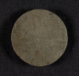 Round, flat disc of grey shale or slate