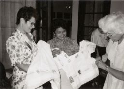 Three women examining clothing