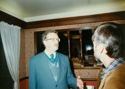 Two men talking at a party