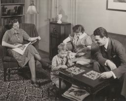 Family sitting together, reading and playing board games
