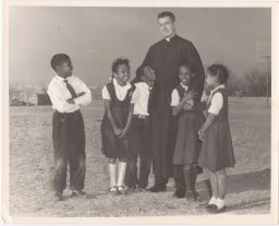 Philip Berrigan with African-American children smiling
