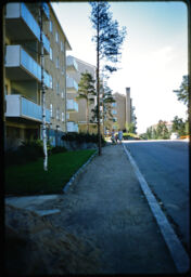 Neighborhood sidewalk and street showing nearby multi-story residential buildings (Hiitomaki, Helsinki, FI)