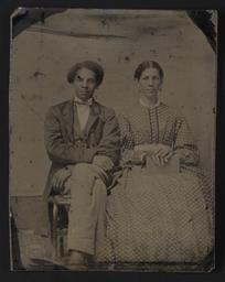 Portrait of a seated man and woman holding book