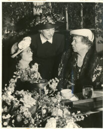 Rose Schneiderman and Eleanor Rooselvelt seated at table, with unknown woman standing behind them