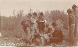 Men examining animal, bent on right