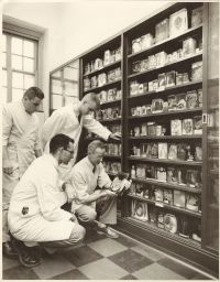 Photo of Dr. Peckham examining pathological specimens for poultry diseases.