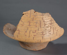 Large fragmentary vessel with truncated conoidal lower  section slipped yellow, incised and retraced with red.