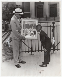 Captain Hugh N. Mulzac showing a painting to Richard Lacy
