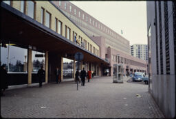 Pedestrian street towards a large building and a residential tower (Farsta, SE)