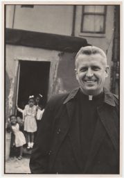Philip Berrigan smiling, with African-American girls in background.