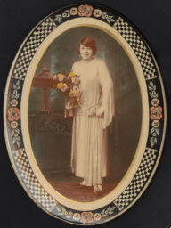 Portrait in an oval button frame of young woman in a white dress holding flowers