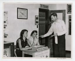 Customer interacting with two employees at the Tweetsie mail service desk inside depot