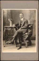 Man seated with arm resting on sidetable