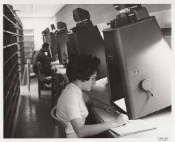 Carolyn Hersh using a microfilm reader in Olin Library.