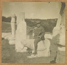 [Western man in uniform posing on statue]