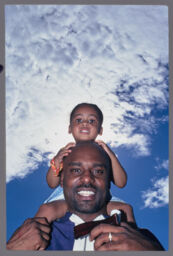 unidentified man with child on his shoulders