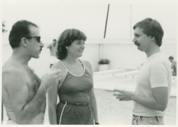 Men and woman talking by poolside on Fire Island trip