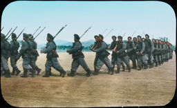 A line of Japanese soldiers in the midst of marching across a field